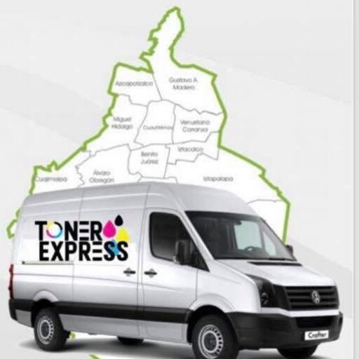 Cuatro cartuchos de tóner de colores negro, cian, magenta y amarillo se encuentran sobre un escritorio con cajas de empaque y una impresora al fondo.